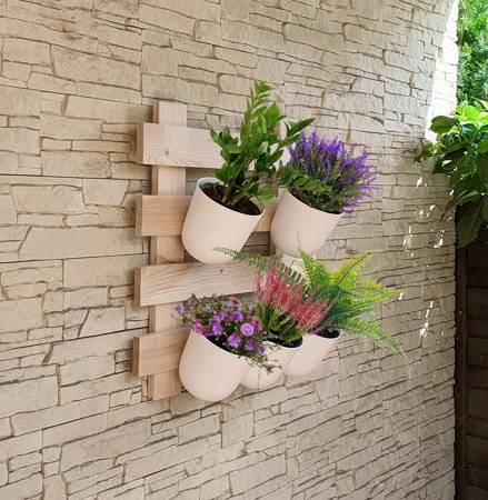 Wooden, raw flowerbed hanging on the wall